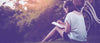 Femme en train d'écrire dans un journal intime au pied d'un arbre dans l'herbe avec une bicyclette Mon-journal-intime.com